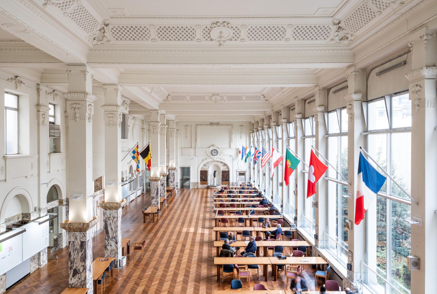 The Antwerp Diamond Bourse trading hall, with rows of tables and international flags