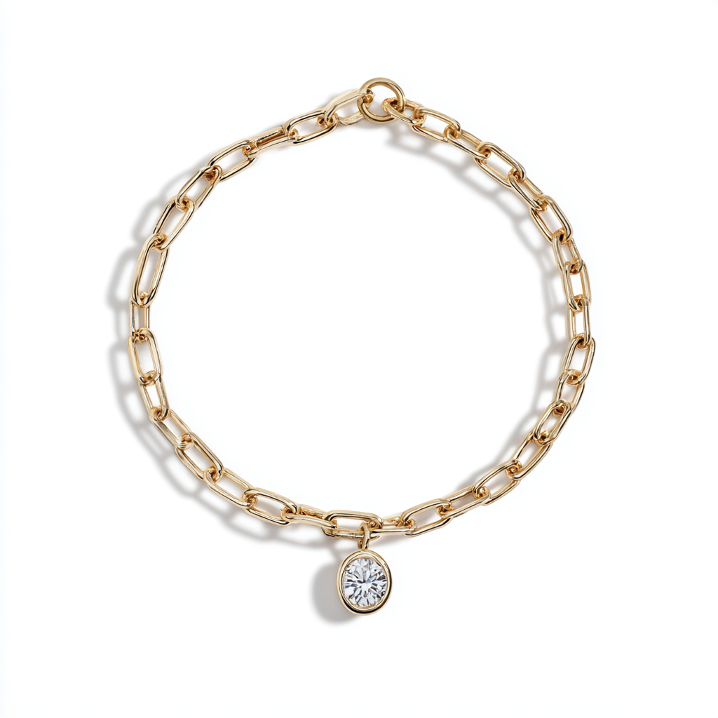 A yellow-gold paperclip-link chain bracelet with a single bezel-set diamond charm